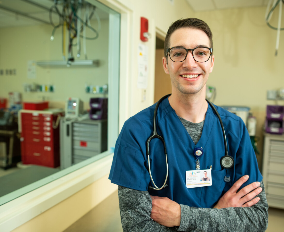 man smiling blue scrubs arms crossed