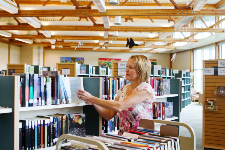 Librarian replacing books on shelves