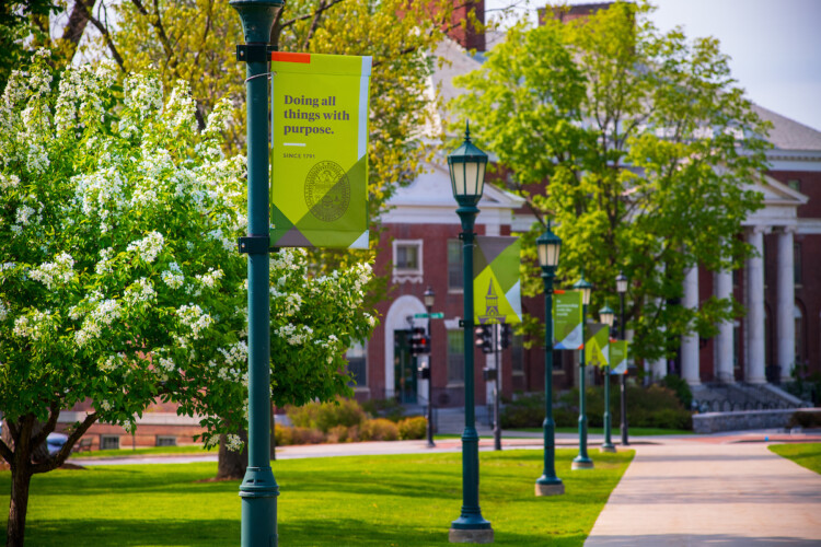 UVM Campus with sign Doing all things with purpose