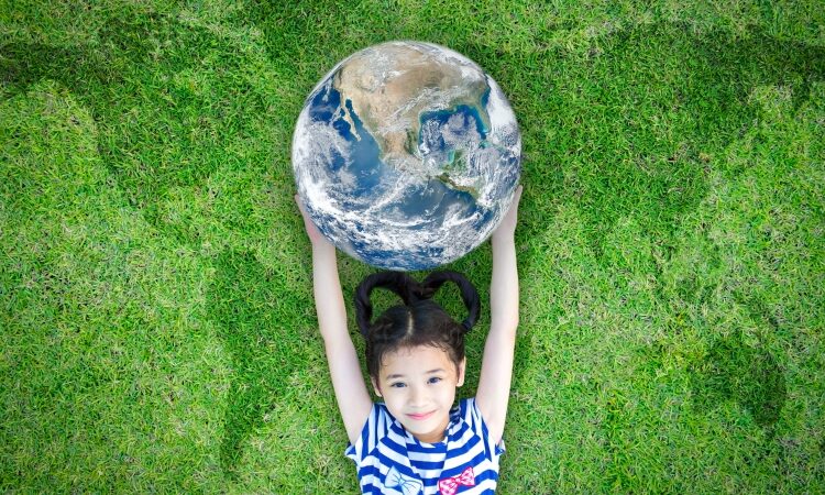 girl holding globe on grass for public health