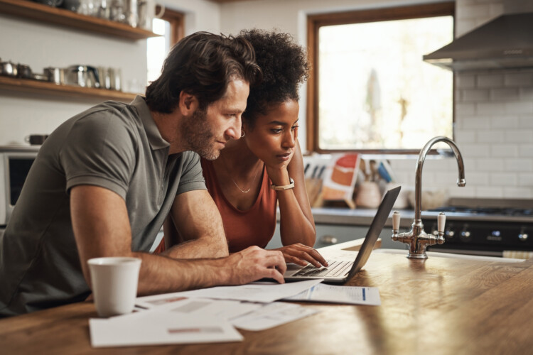 man and woman looking at application on computer in kitchen