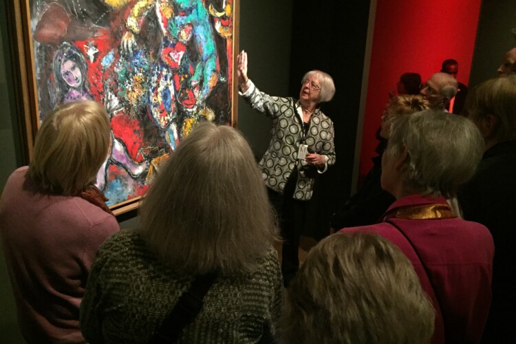 woman showing artwork to OLLI members